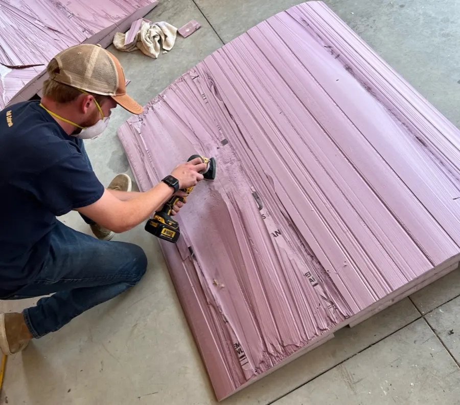 Team member sanding the surface of a foam airfoil.