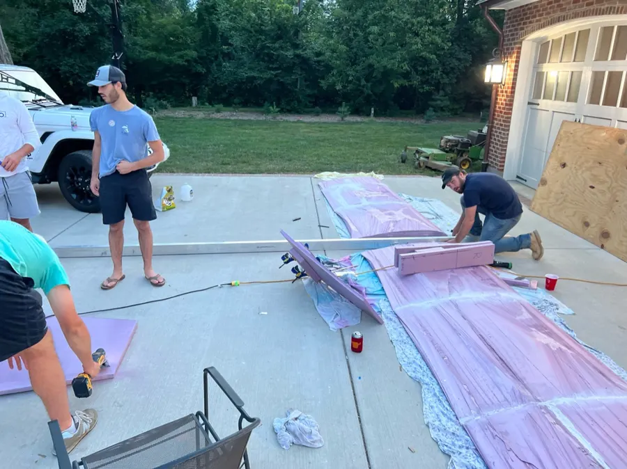 Team members working on the foam wing sections on a driveway.